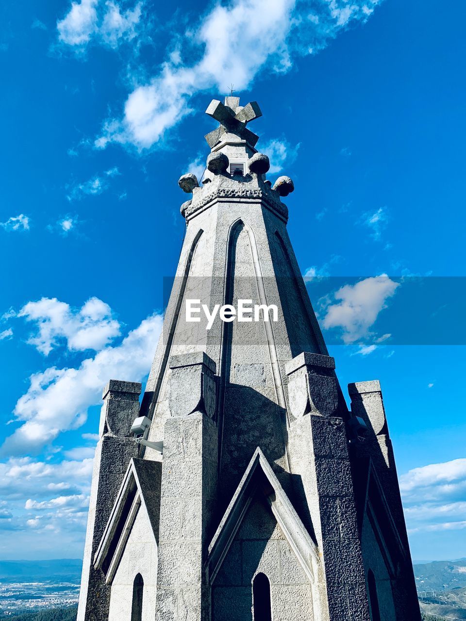 Low angle view of statue by building against sky