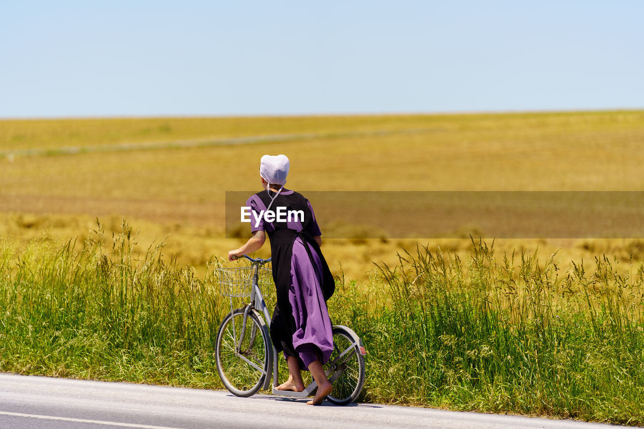 Side view of woman cycling on road