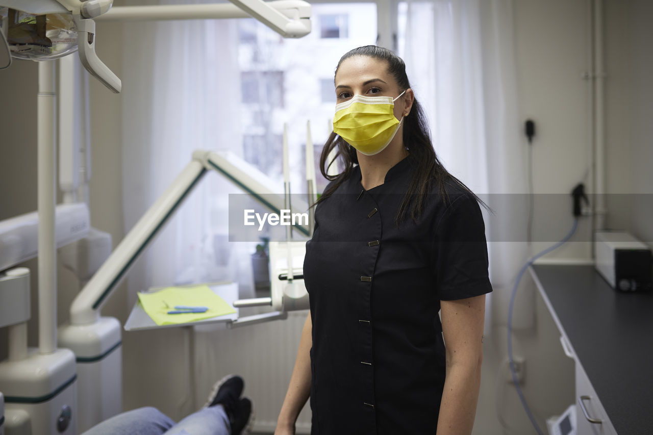 Female dentist standing in office