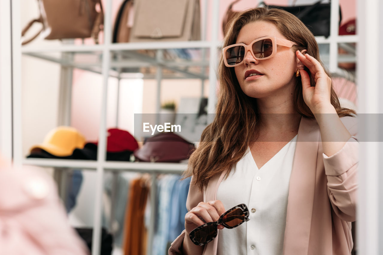 Young woman wearing sunglasses at store