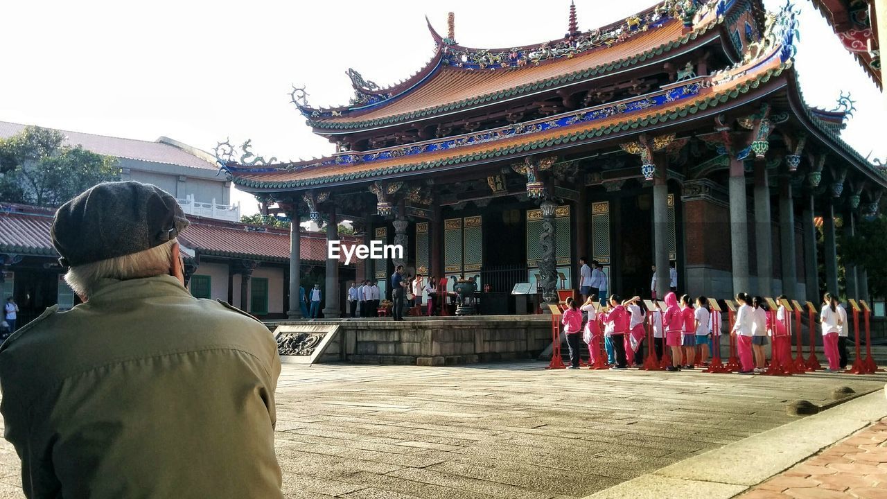 Rear view of man looking at choir singing by confucius temple