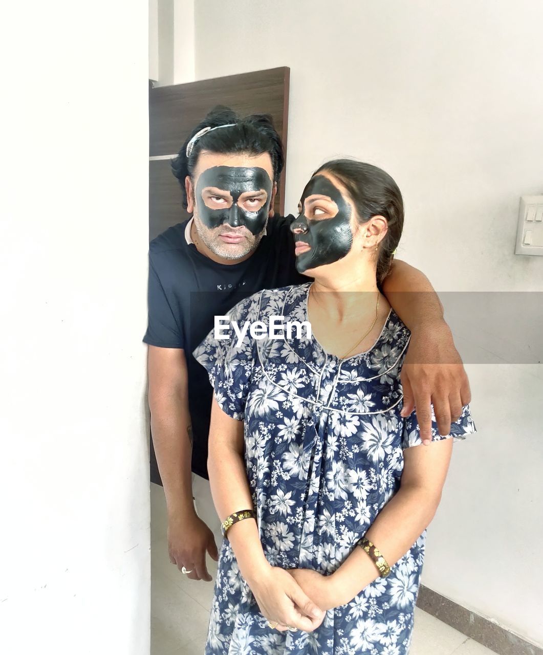 Young couple standing against wall