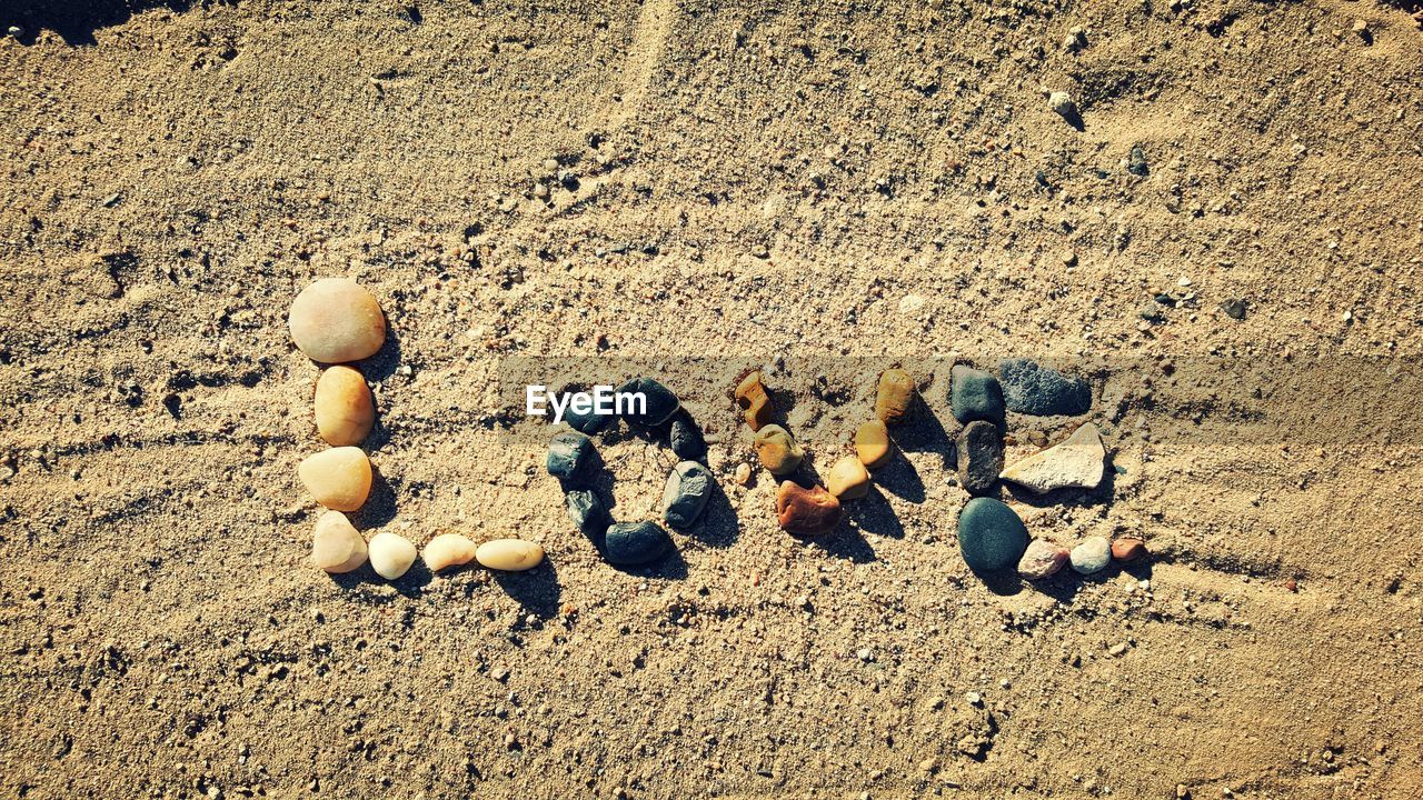 High angle view of love text made of stones on sand at desert