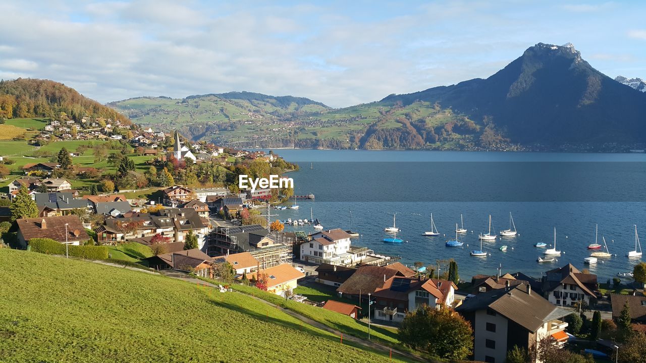 Scenic view of sea by houses and mountains against sky