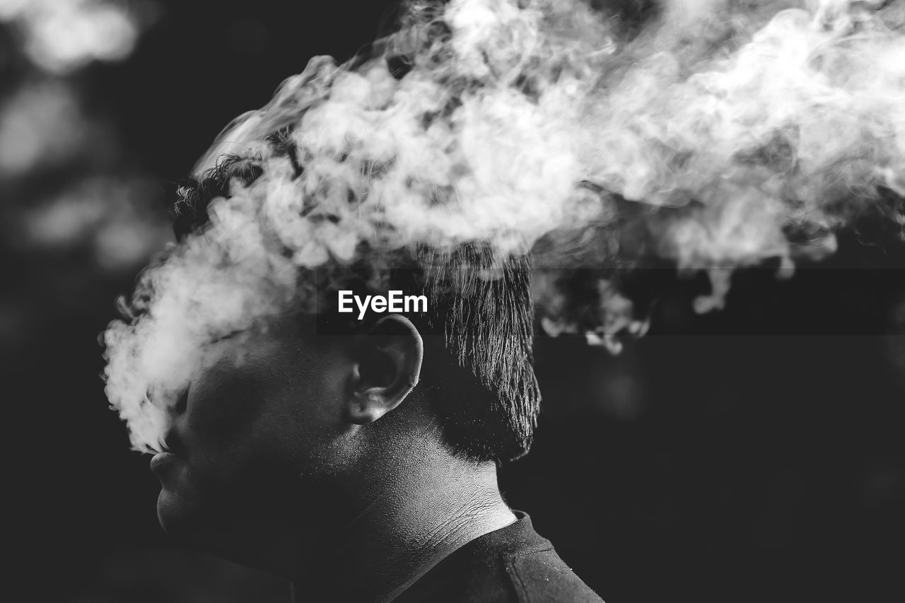 Close-up portrait of young man smoking outdoors