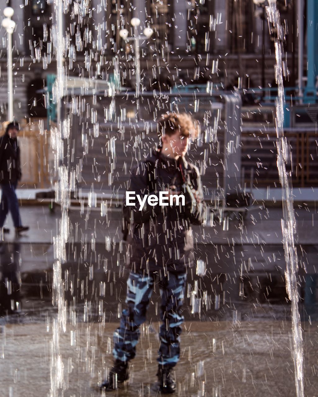 Teenage boy standing by fountain