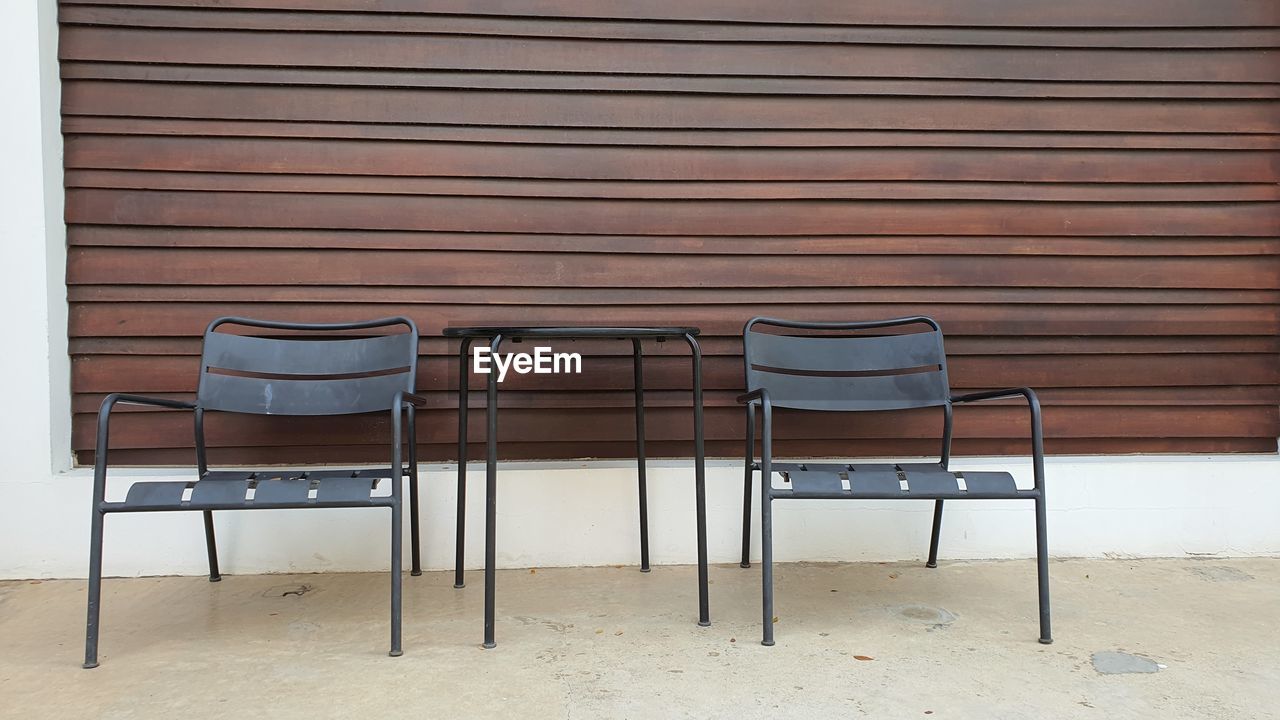 CHAIRS AND TABLE AGAINST WALL