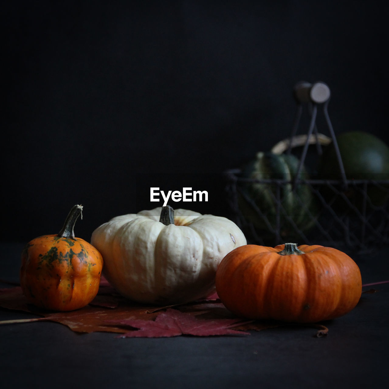 Pumpkins on table against black background