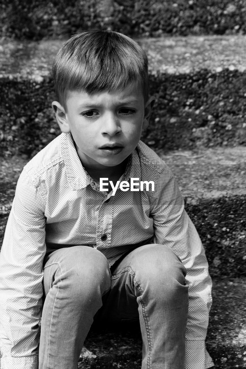 Boy sitting on steps outdoors