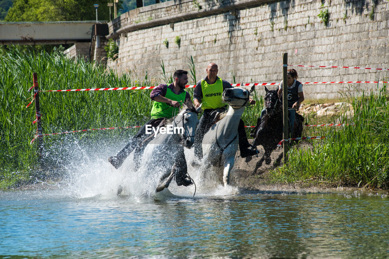 GROUP OF PEOPLE IN WATER AT CANAL