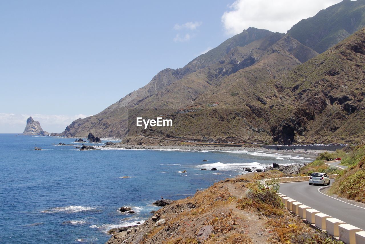 Scenic view of sea and mountains against sky