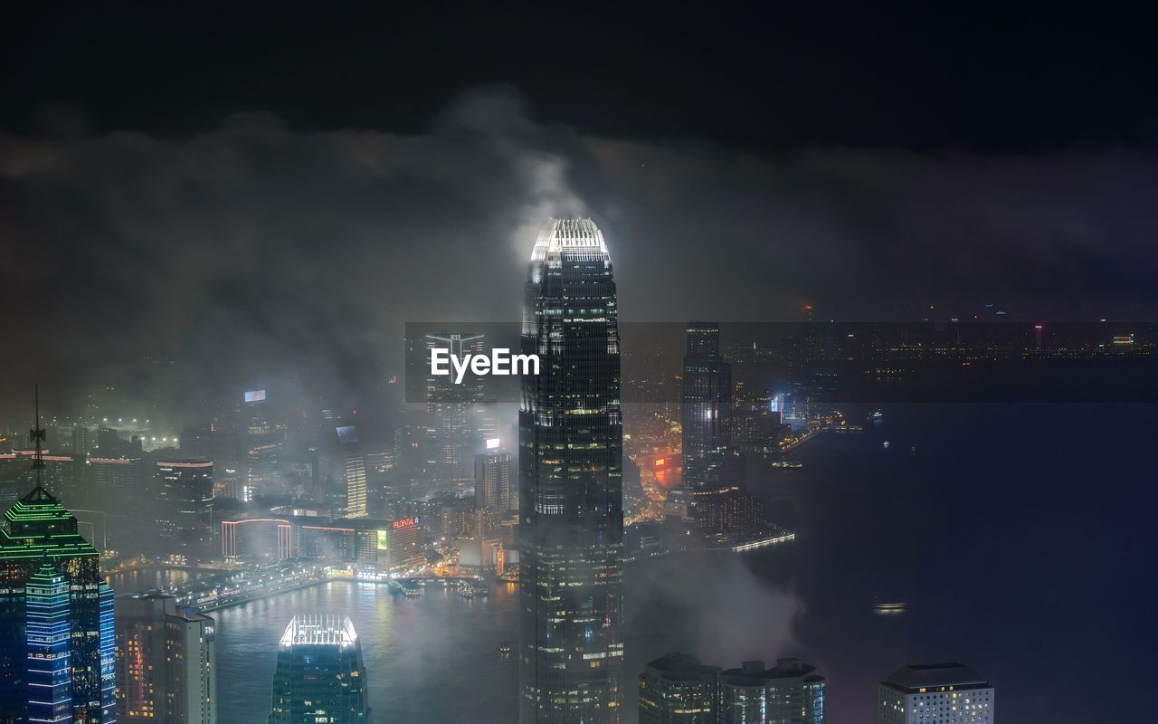 Illuminated buildings in city against sky at night