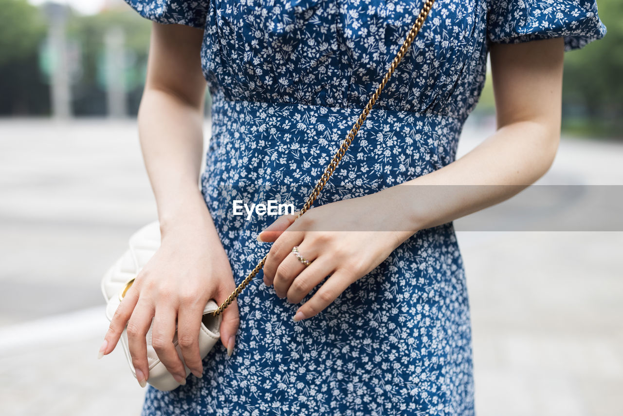 Midsection of woman standing against blurred background