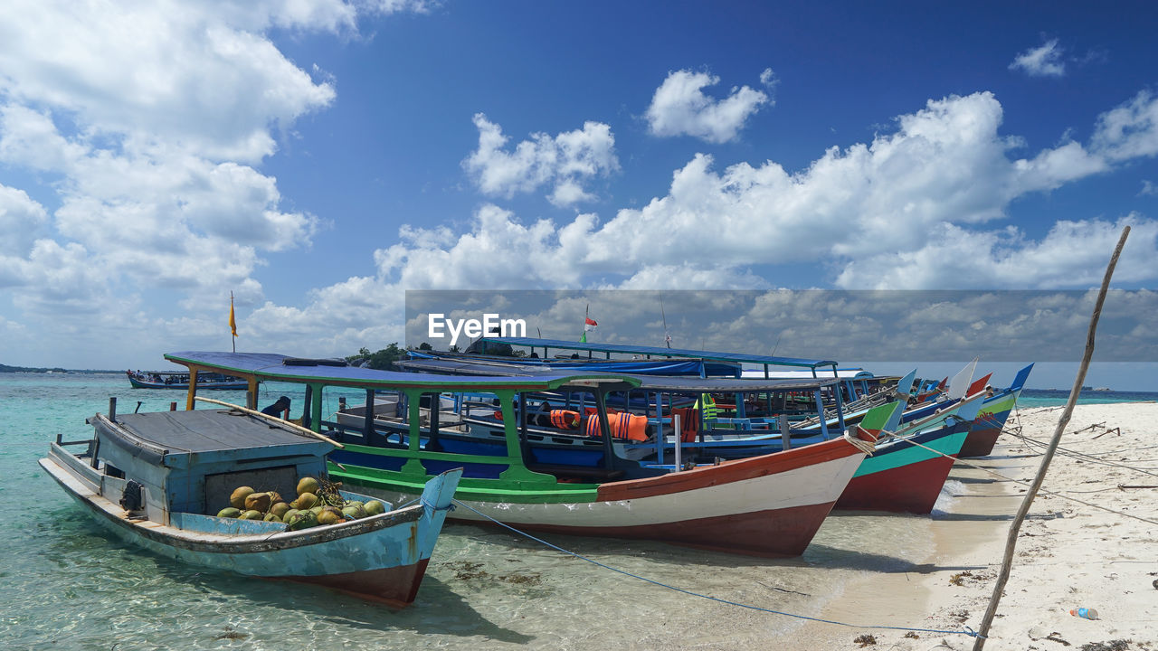 BOAT MOORED ON SEA AGAINST SKY