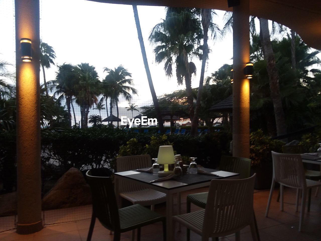 EMPTY CHAIRS AND TABLES AT SWIMMING POOL