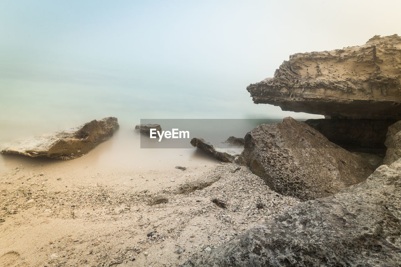 SCENIC VIEW OF ROCKS IN SEA AGAINST SKY