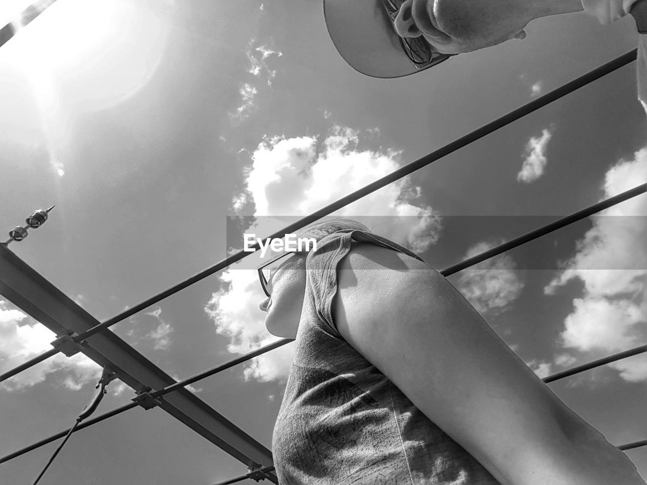 Low angle view of man and woman walking against sky on sunny day