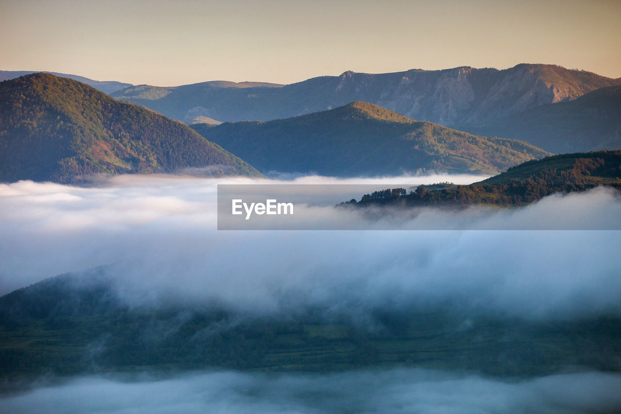 Scenic view of mountains covered with clouds against sky