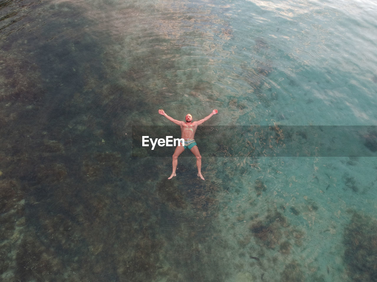 High angle view of shirtless man swimming in sea