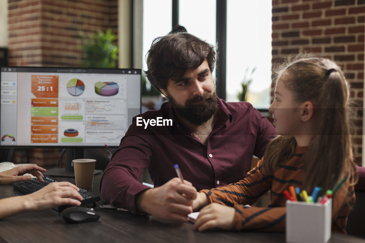 Businessman talking with girl at office