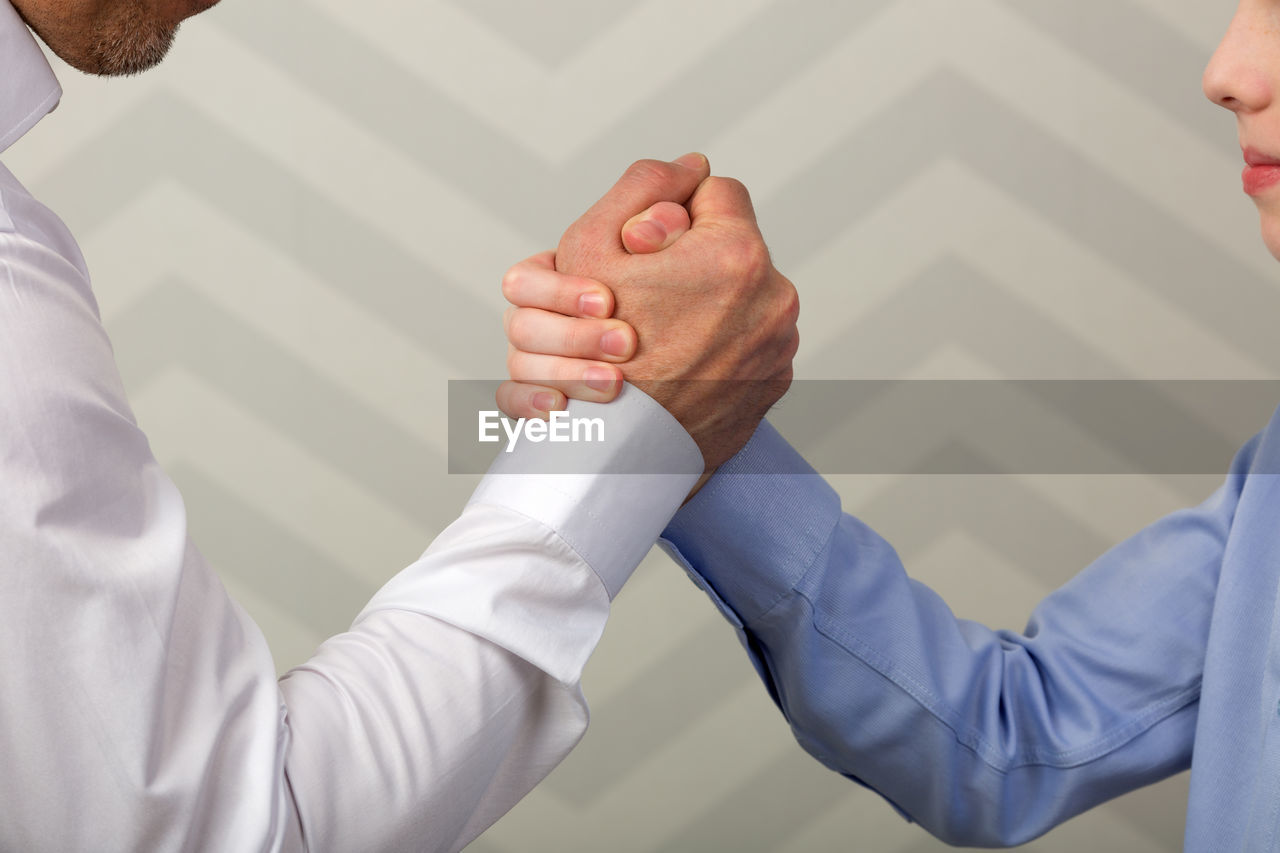 Midsection of business people holding hands