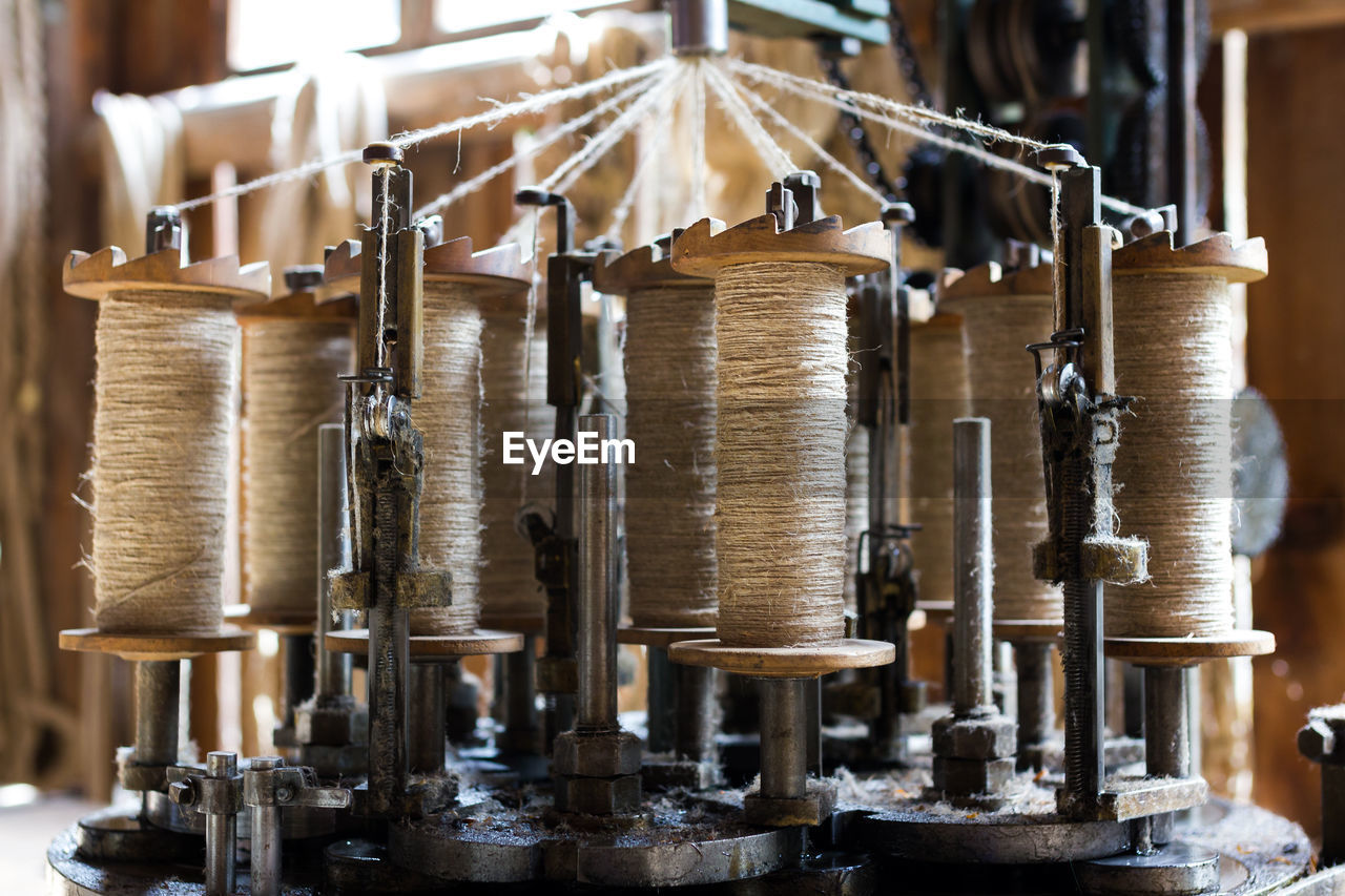 Close-up of spools in machinery at textile industry