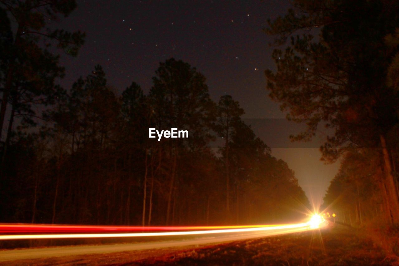 View of light trails on country street at night