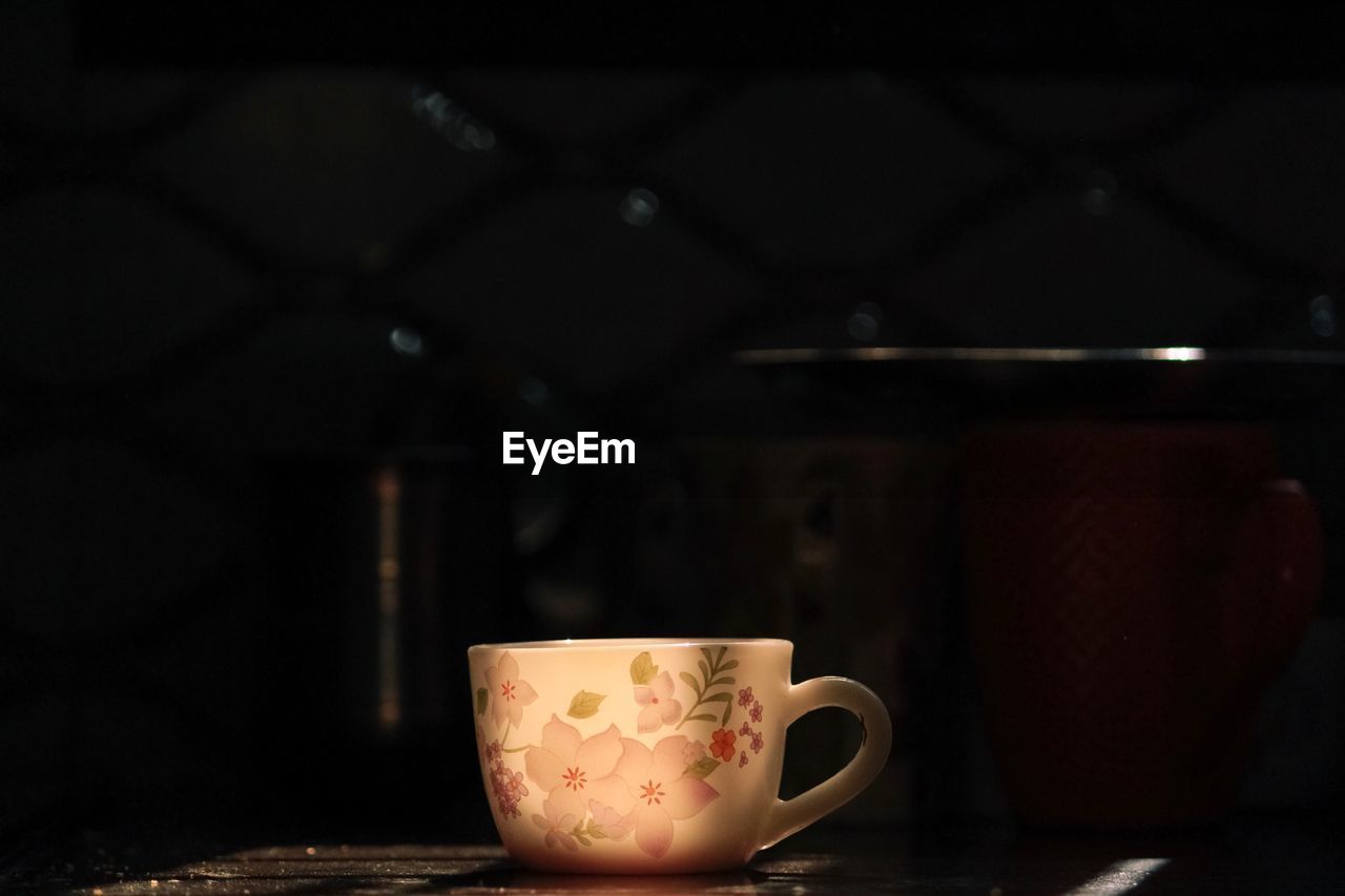 CLOSE-UP OF COFFEE CUP ON TABLE AT HOME