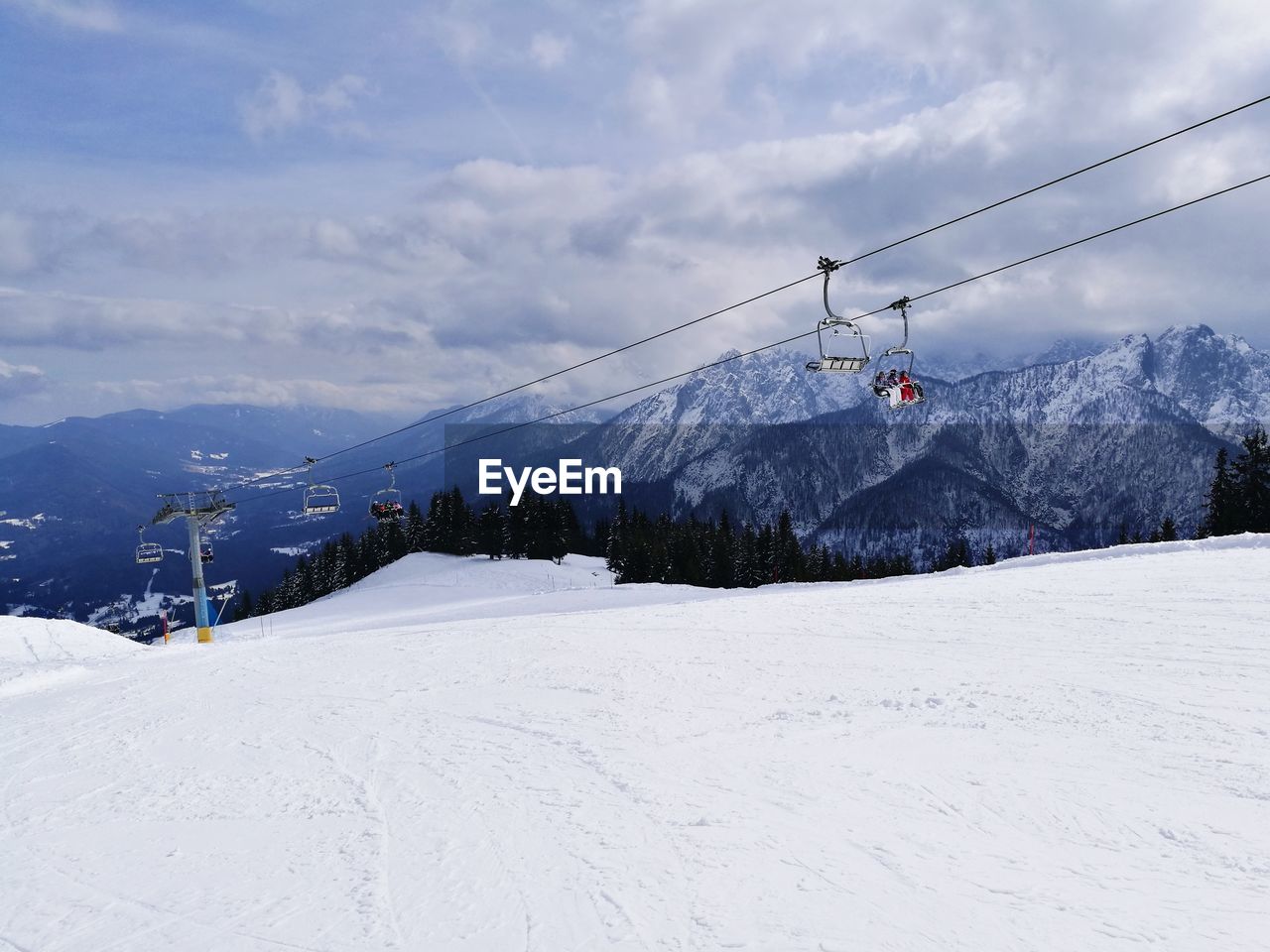 OVERHEAD CABLE CAR AGAINST SNOWCAPPED MOUNTAINS