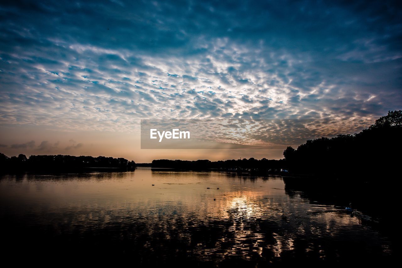 SILHOUETTE TREES BY LAKE AGAINST SKY AT SUNSET