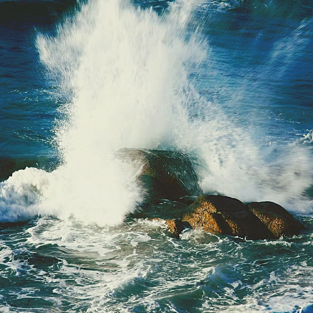 Close-up of water splashing over rocks in sea