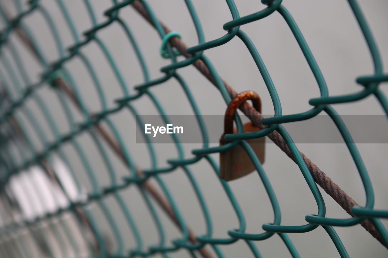 Close-up of padlock on chainlink fence