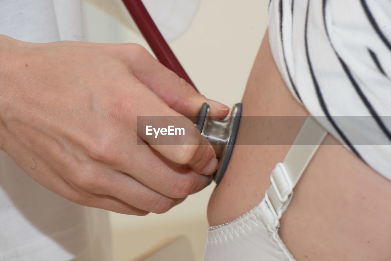 midsection of doctor examining patient at clinic