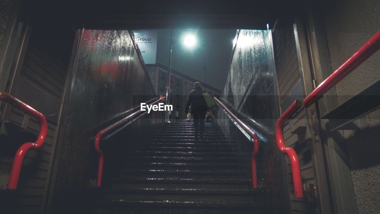 Low angle view of woman walking on steps at night