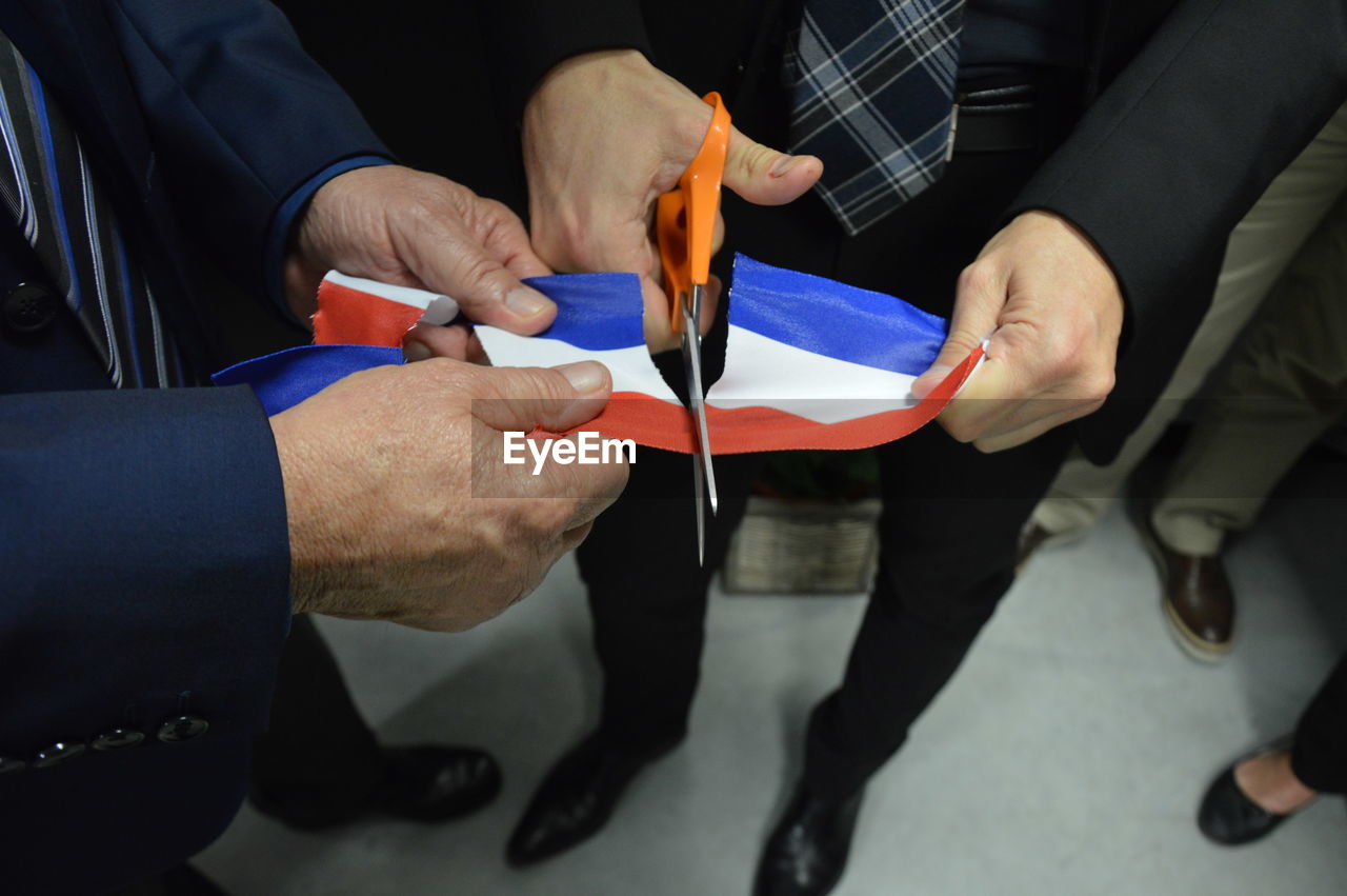 Low section of people cutting thai flag