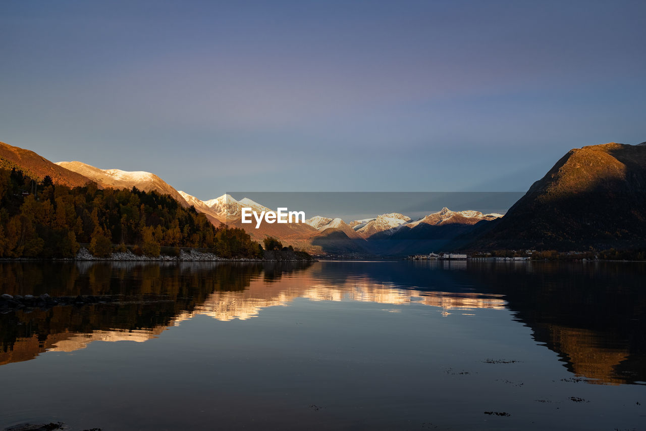 Scenic landscape with snowy mountains and Åndalsnes town on distant shore. panoramic view.