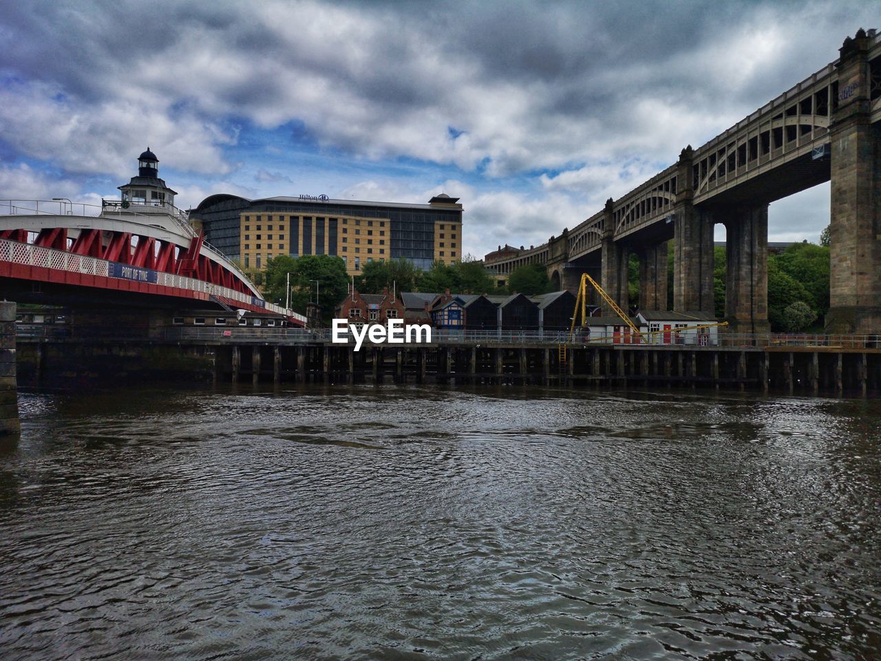 Bridge over river against buildings in city