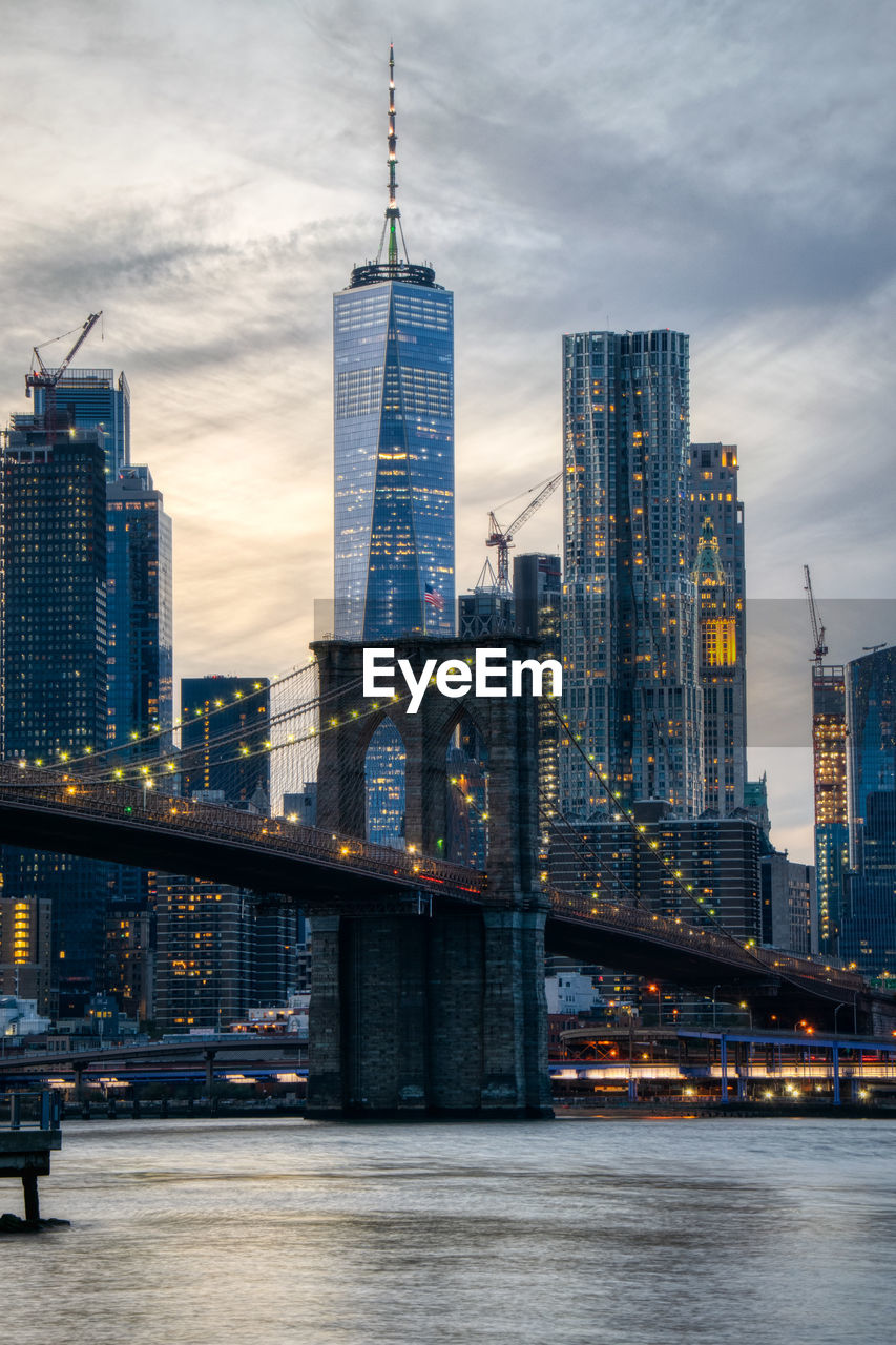 Bridge over river against buildings in city