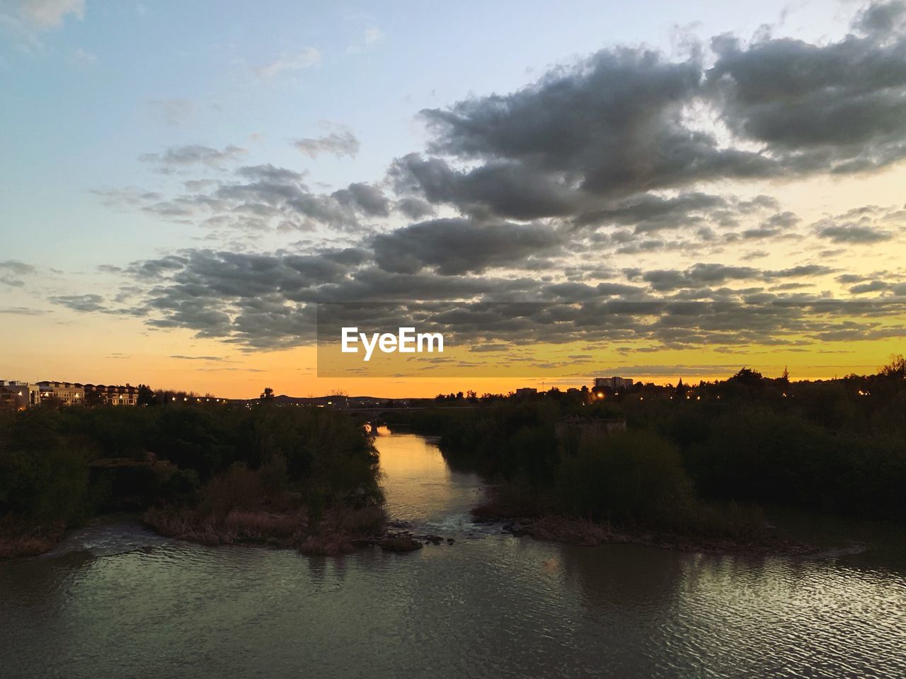 SCENIC VIEW OF RIVER BY TREES AGAINST SKY DURING SUNSET