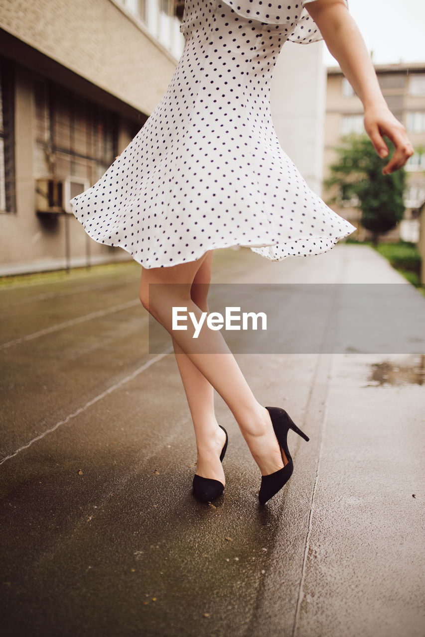 Woman in polka dot dress dancing in the rain