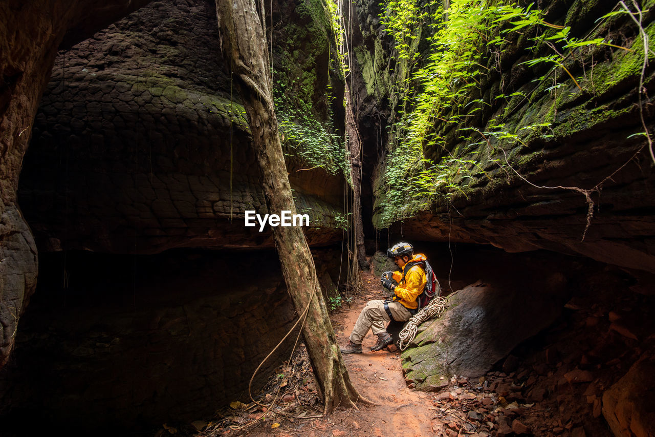 MAN AMIDST ROCKS AT FOREST