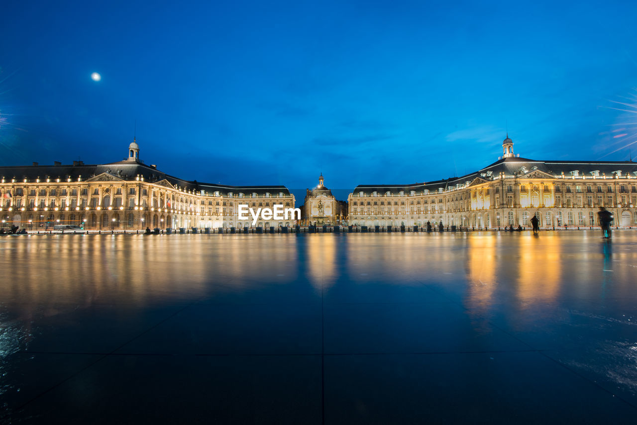 Reflection of illuminated building in water at night