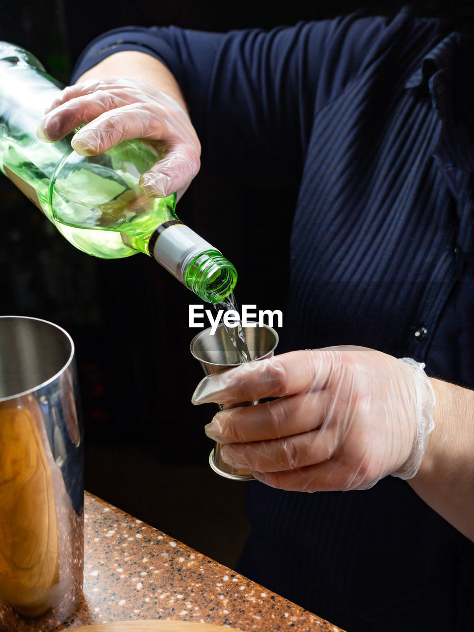 MIDSECTION OF MAN PREPARING FOOD IN GLASS