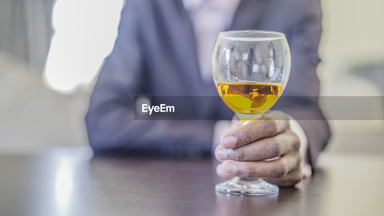 Close-up of man holding wineglass