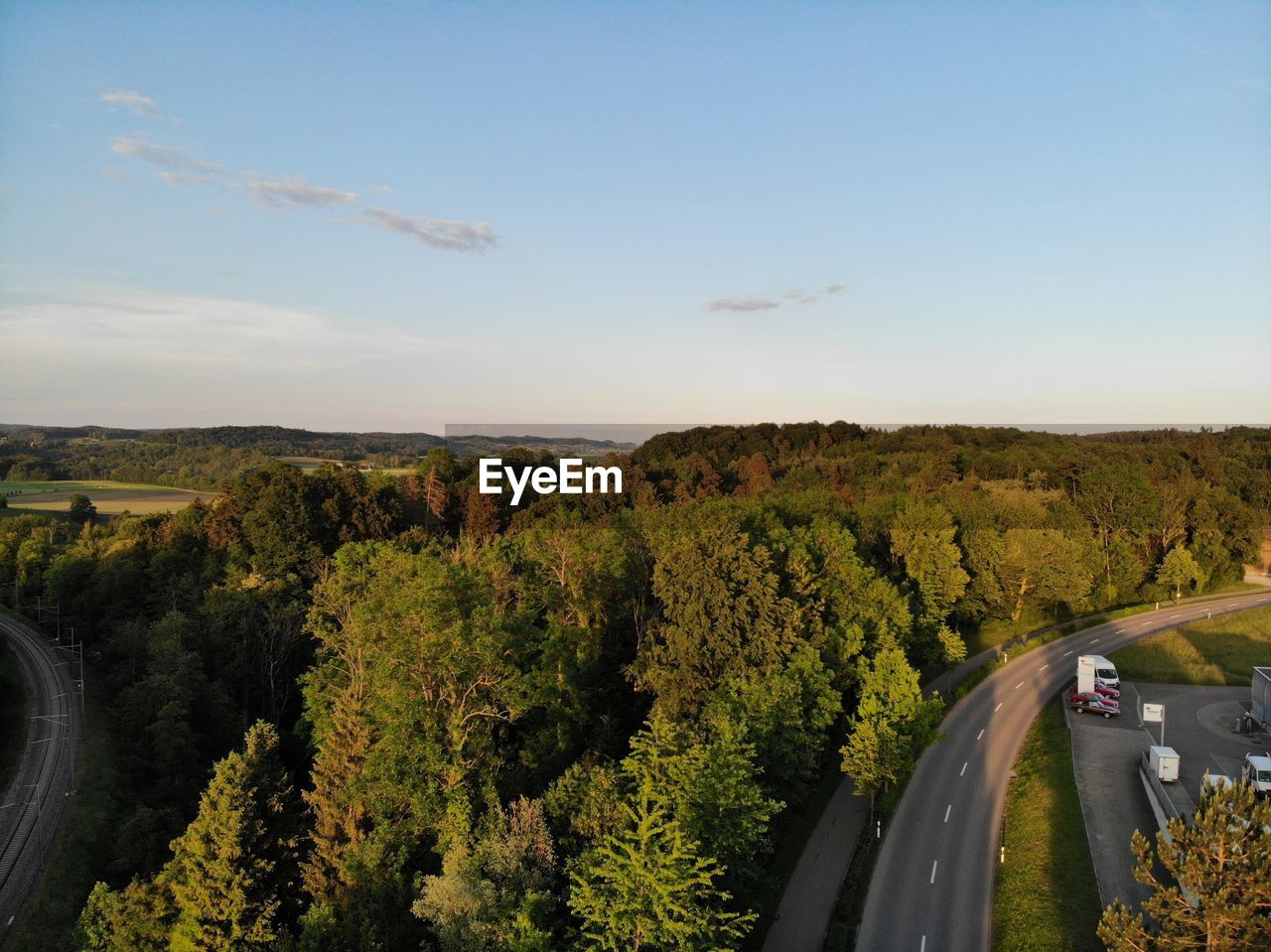 ROAD BY TREES AGAINST SKY