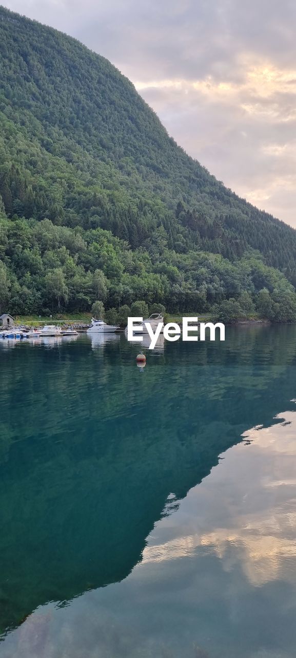 SCENIC VIEW OF LAKE BY MOUNTAIN AGAINST SKY