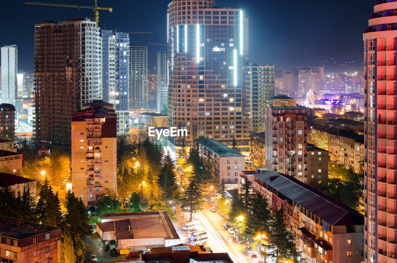 Illuminated buildings in city against sky at night