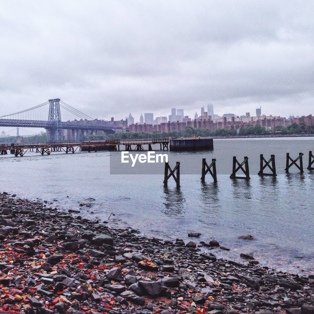 Ship yard by bridge against sky