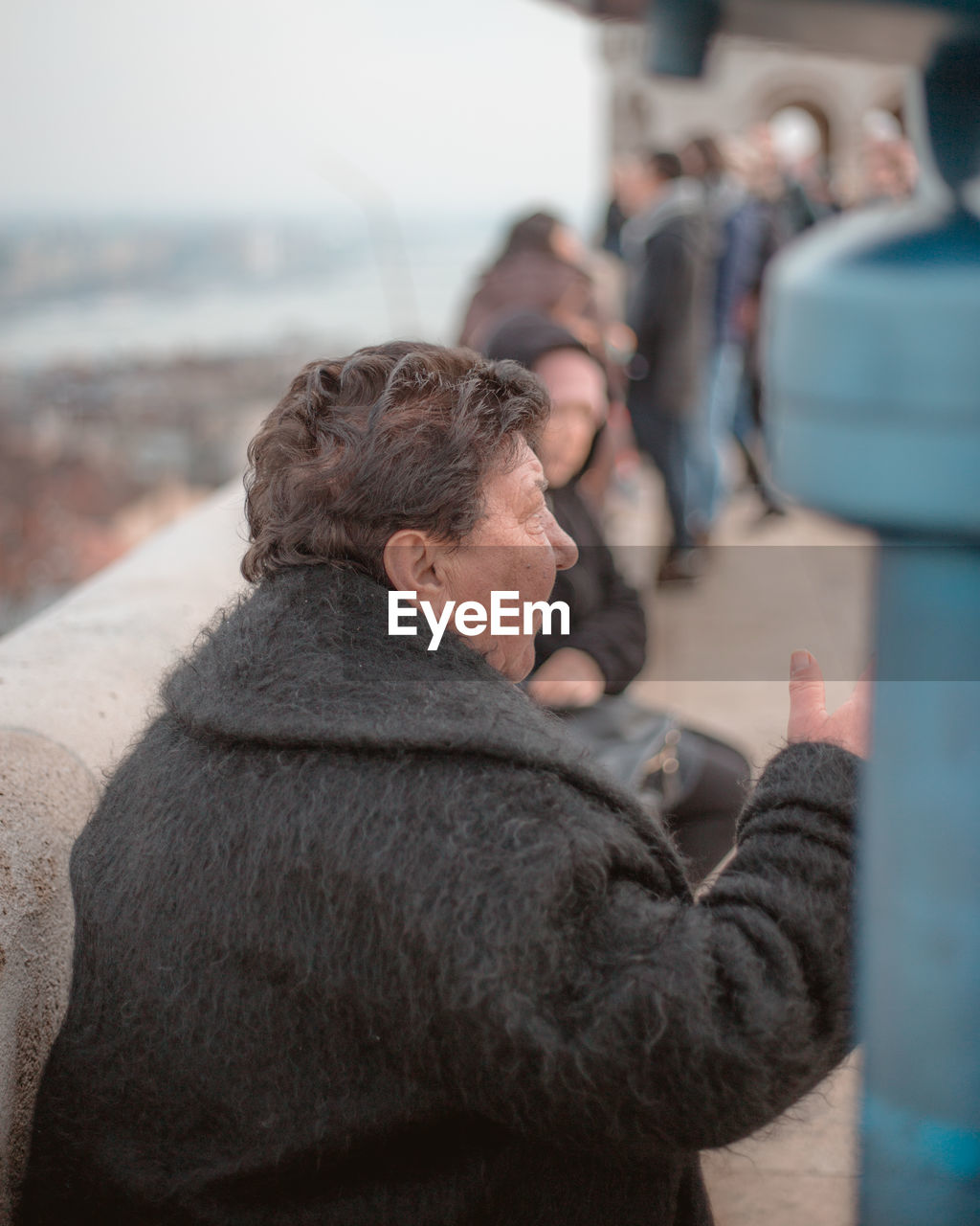 REAR VIEW OF MAN AND WOMAN USING PHONE