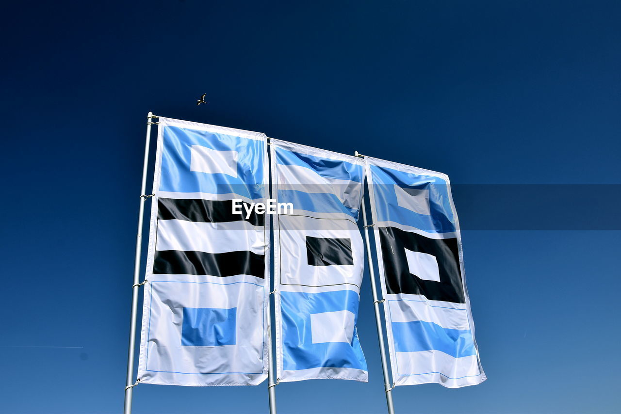 blue, flag, patriotism, sky, no people, nature, clear sky, wind, environment, copy space, low angle view, advertising, striped, white, outdoors